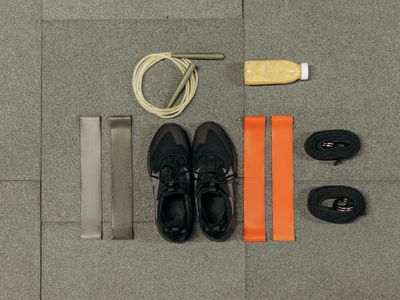 Resistance bands and light weights on a wooden surface